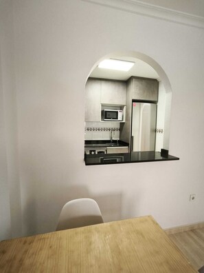 Una cucina con forno a microonde, frigorifero e lavello.