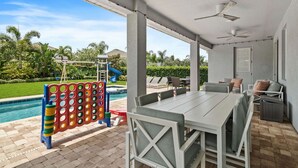 Un patio al aire libre con piscina, zona de estar y parque infantil.