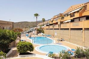 A hotel with a swimming pool, lounge chairs, and a desert landscape in the background. - Home2Book Casa Mimou Costa Adeje, Pool & Terrace (Adeje)