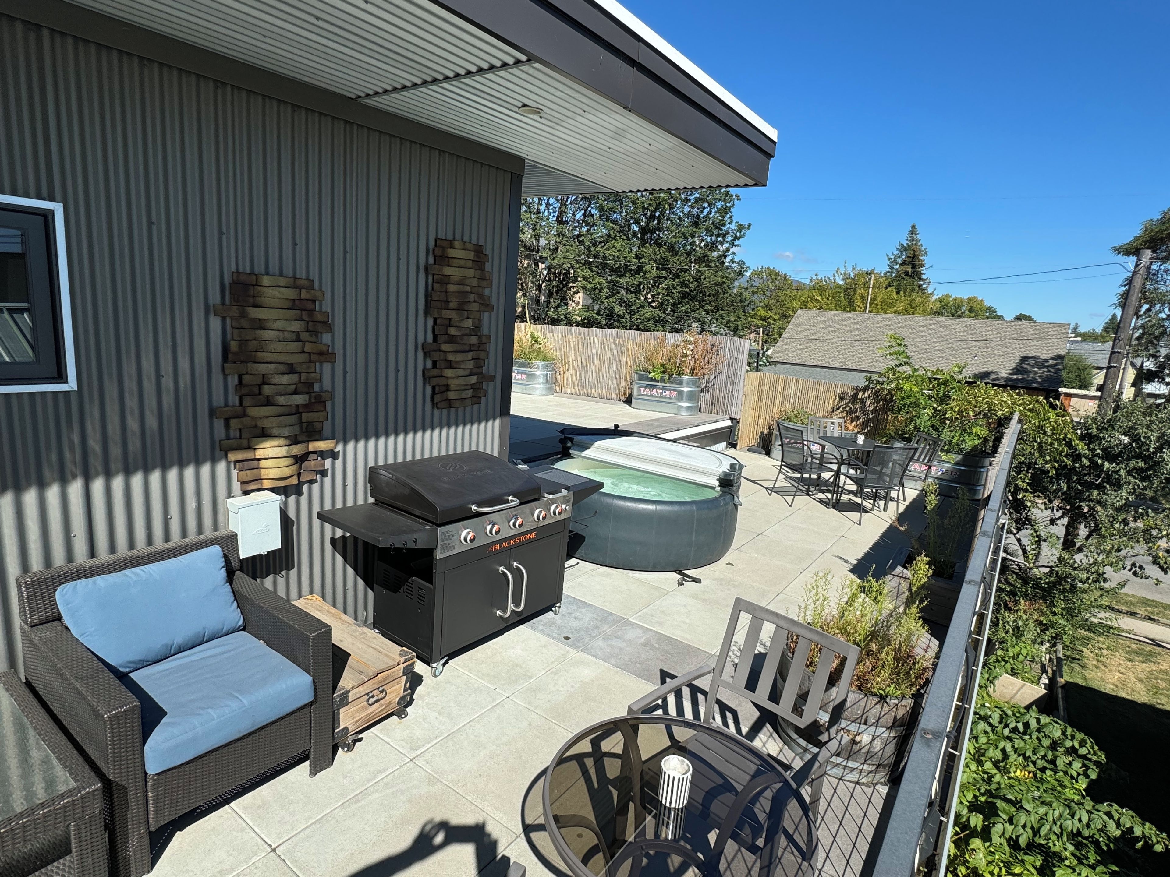 A patio with a grill, outdoor furniture, and a hot tub.
