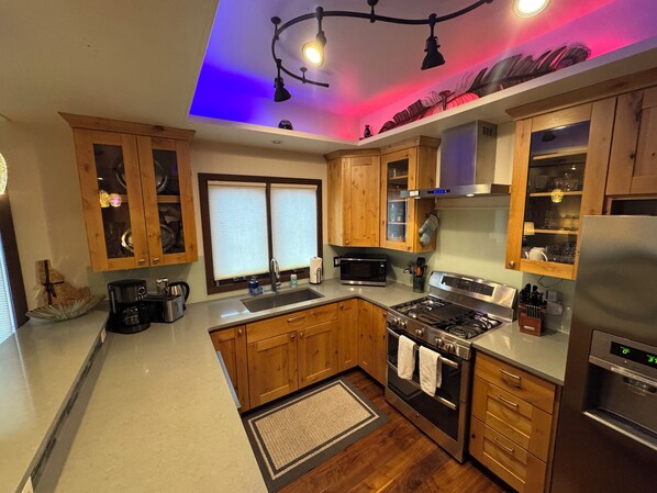 A modern kitchen with wooden cabinets, stainless steel appliances, and a central island.