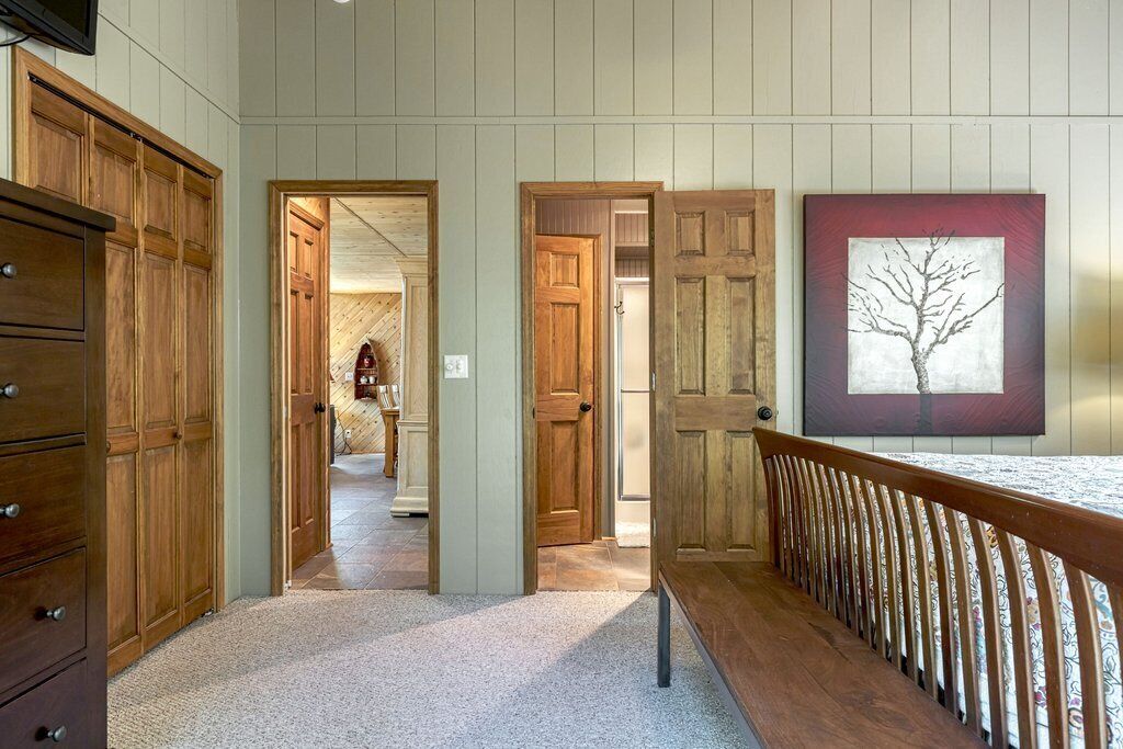 A hallway with wooden doors and a bench.