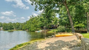 Un parc au bord du lac, avec une plage de sable, une terrasse en bois et un petit quai.
