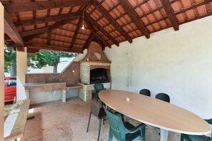 An outdoor patio with a brick oven, a sink, and a table with chairs. - Apartment 2361/116562 (Istria - Muntic), 10000m from the beach (Muntic)