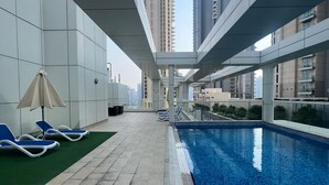 A rooftop pool area with a clear view of tall buildings in the background. - 3-bedroom hostel in lovely Dubai with Wi-Fi, AC, fitness room, breakfast (Dubai)
