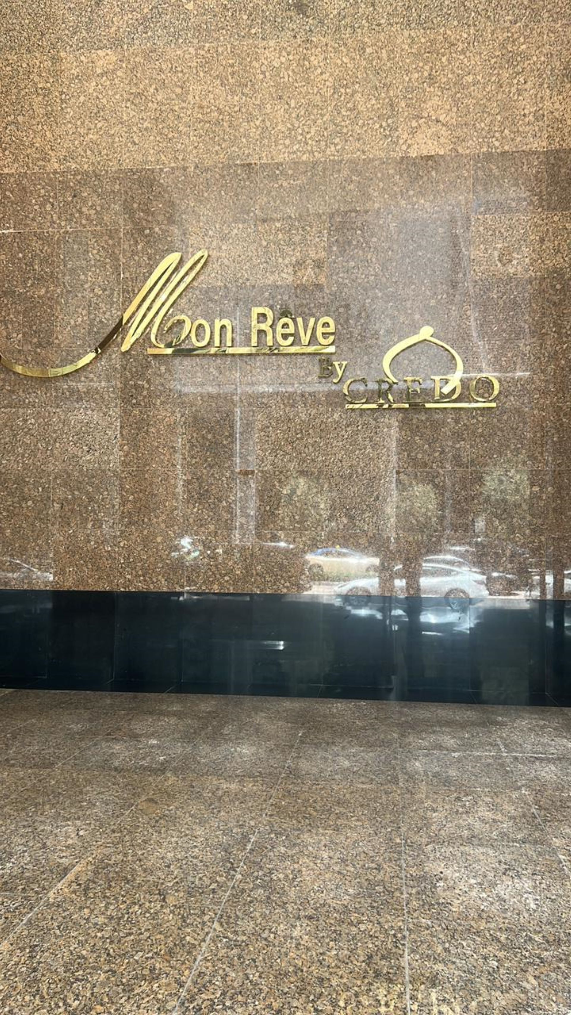 Une enseigne avec les inscriptions « Moon Reve » et « By CREDO » sur un mur à texture.