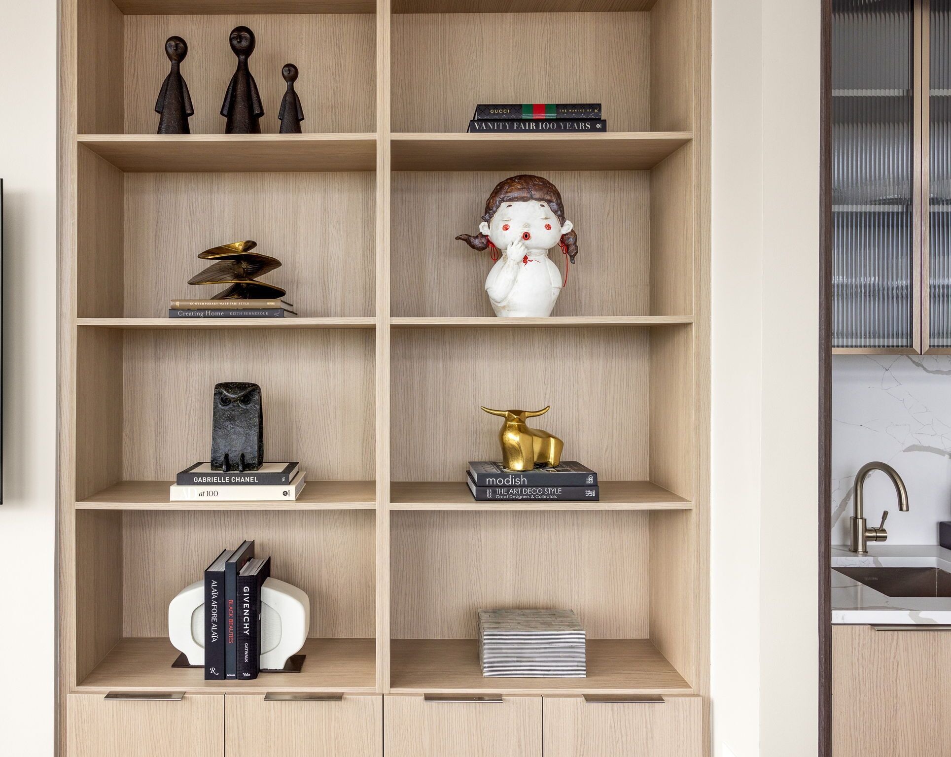 Una estantería de madera con varios objetos decorativos y libros.