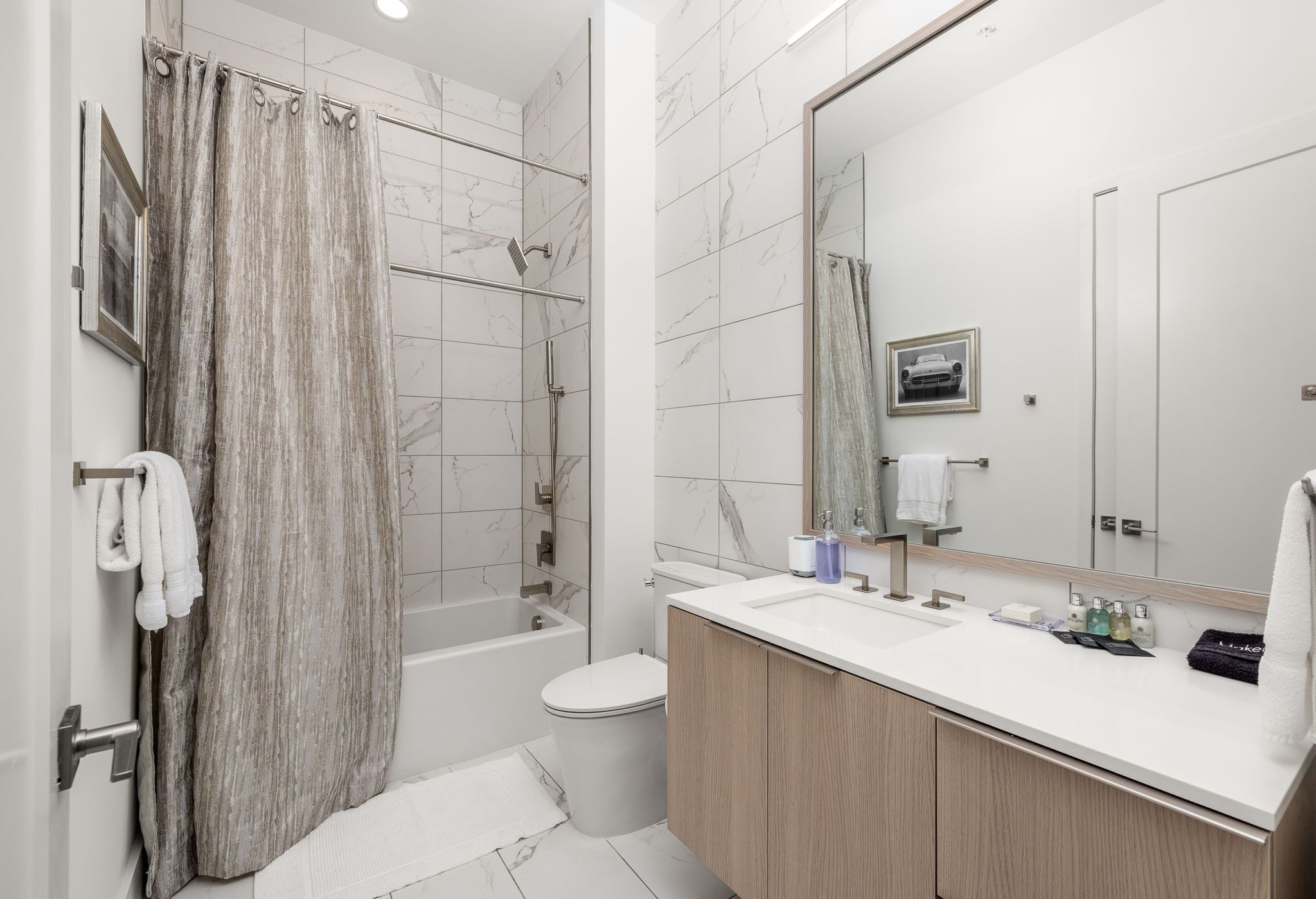 Un baño moderno con ducha, inodoro y tocador.