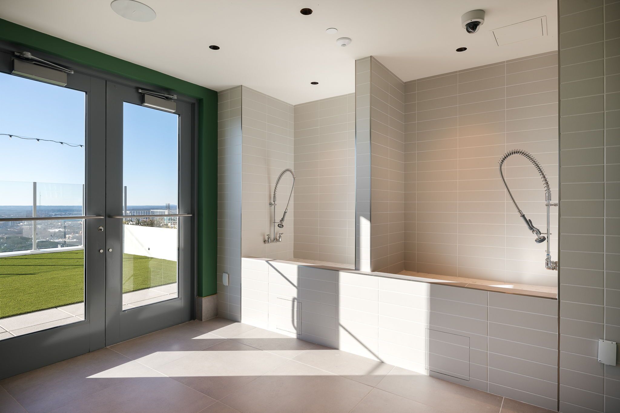 Un baño moderno con un ventanal grande, una ducha y un inodoro.