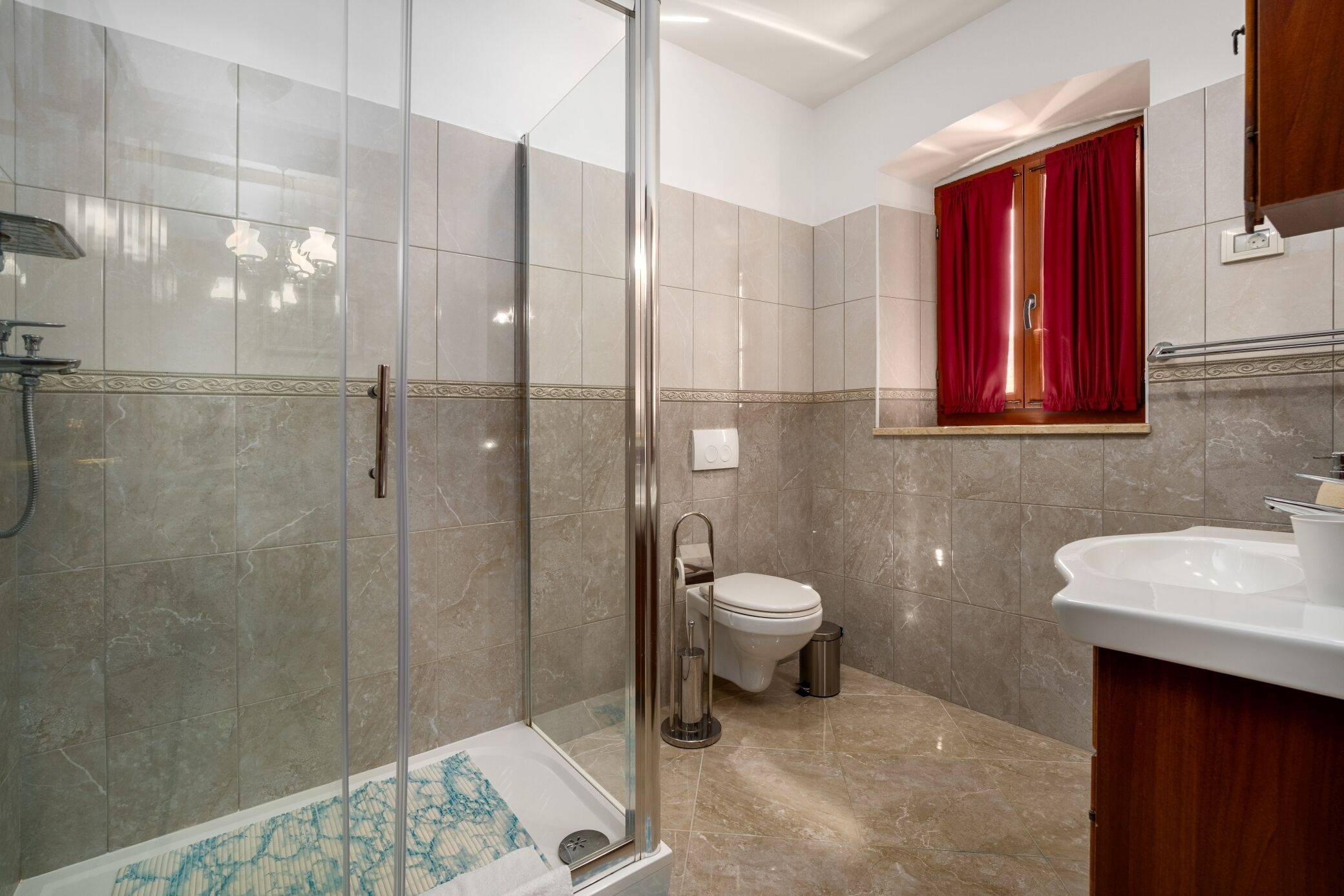 Ein Badezimmer mit Duschkabine, Toilette und Waschbecken.