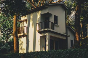 A two-story building with balconies, surrounded by trees and greenery. - Spacious farmhouse with a pool, parking, woods, and rivers (Palin)