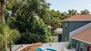 Un jardin avec un jacuzzi, un espace salon extérieur et une piscine.