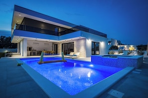 Enjoy a refreshing swim in the outdoor pool surrounded by a spacious patio area.
