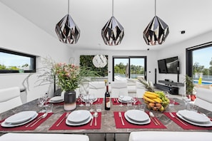 Enjoy meals in this dining area with a set table, wine, and fresh fruit.