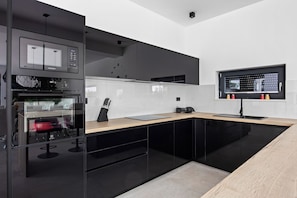 Enjoy cooking in this well-lit kitchen with a large window offering a view of the outdoors.