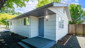 A single-story mobile home with a front porch, a small deck, and a number '68' on the door. - Snug Spot 68: Cozy 1-Bedroom Retreat near Downtown Eugene & Autzen! (Eugene)