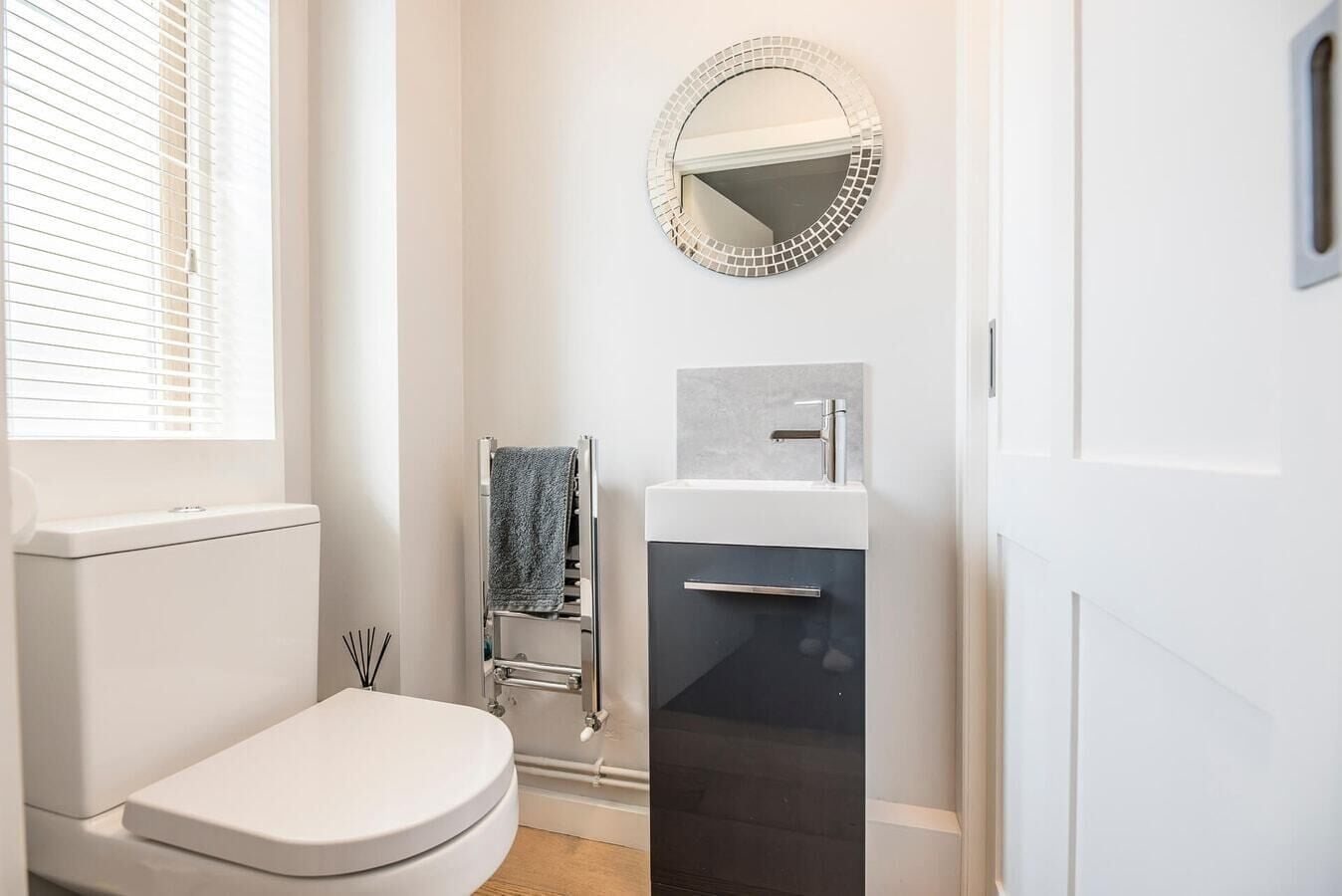 A modern bathroom with a toilet, sink, and towel rack.