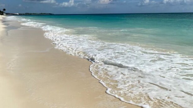 A beach with clear turquoise water and white sand.