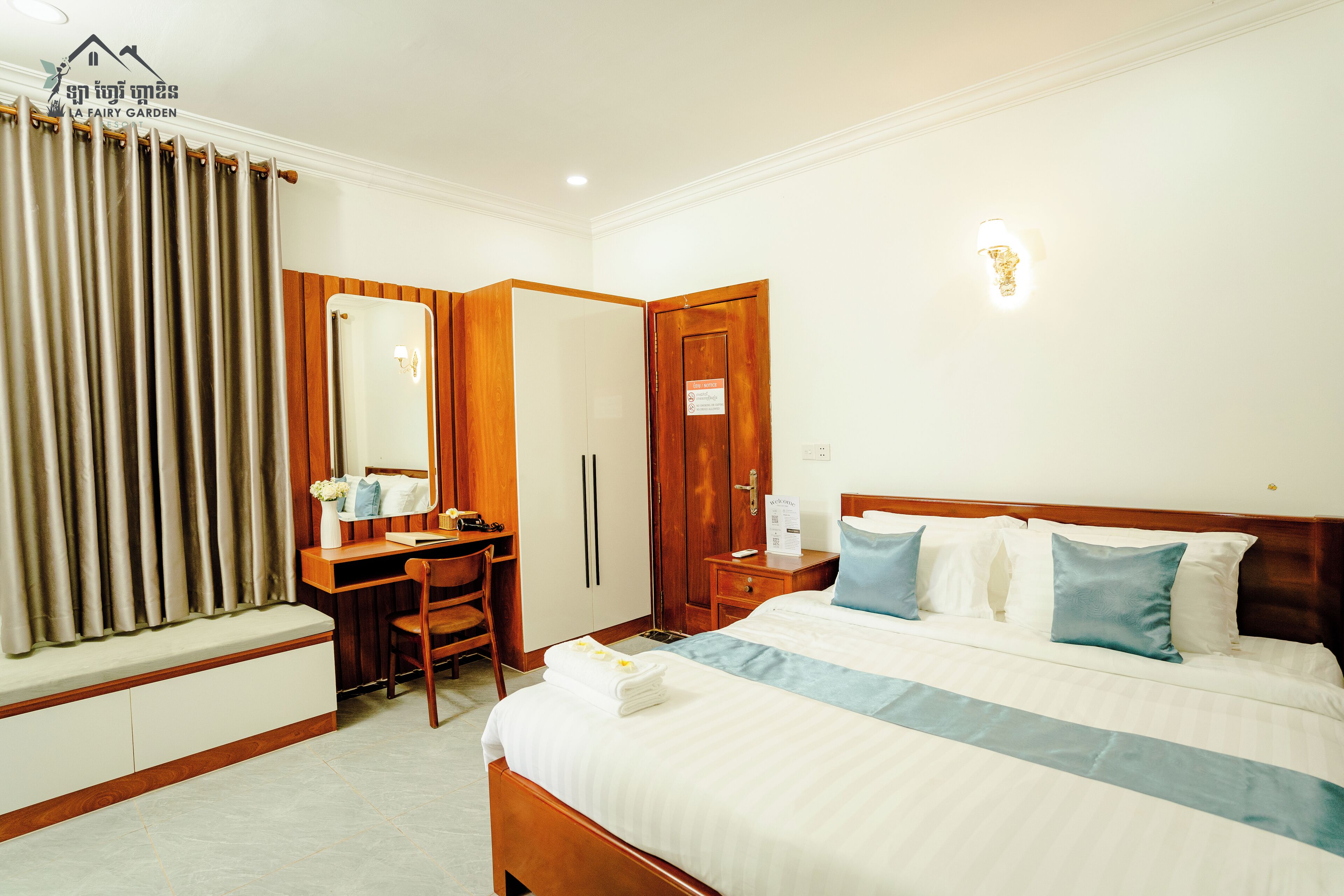 Une chambre d’hôtel comprenant un lit, un bureau, une chaise, une armoire et une salle de bain.