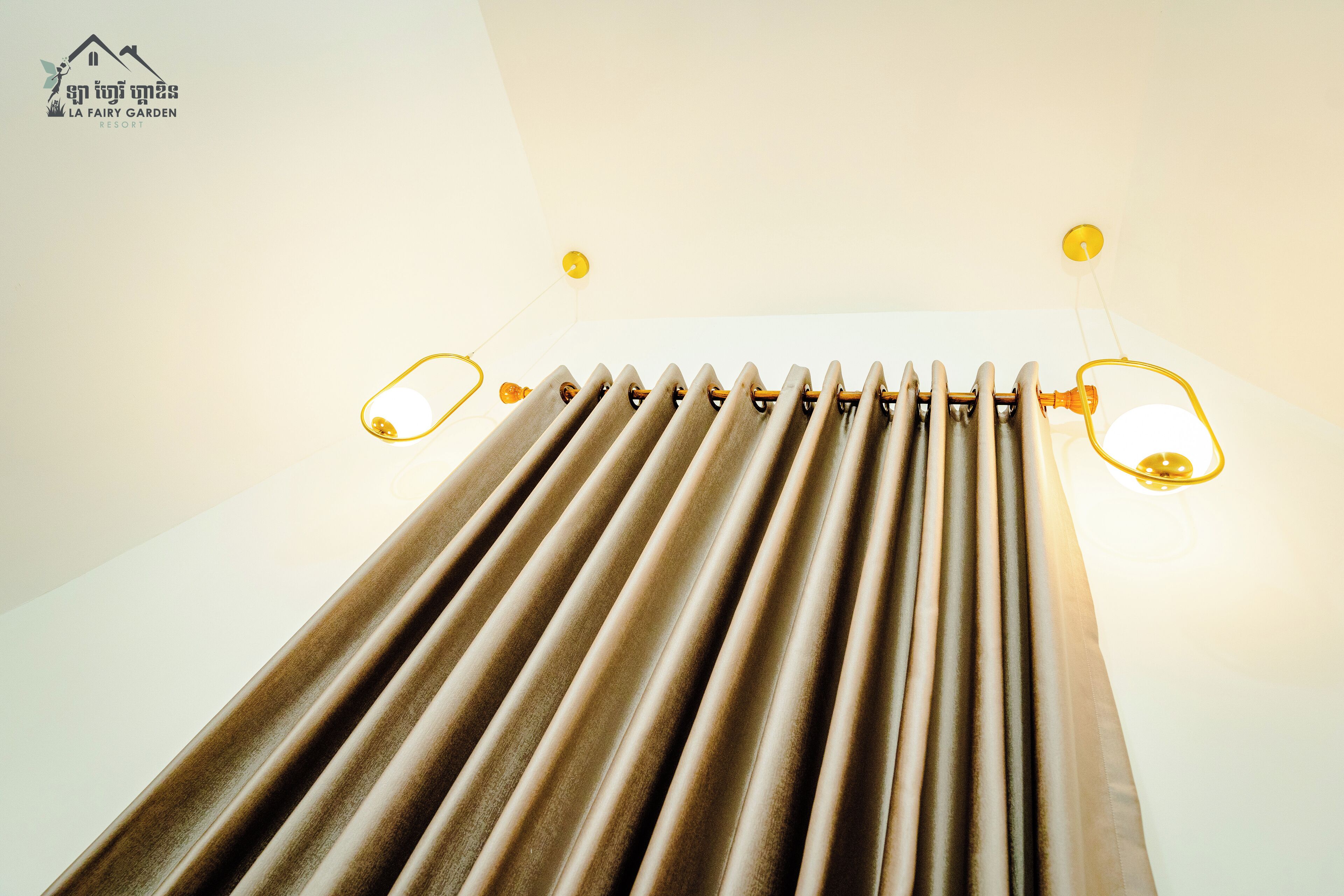 A room with a ceiling fan, a light fixture, and a window with blinds.