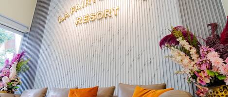 A reception area with a sign reading "LA FAIRY GARDEN RESORT".