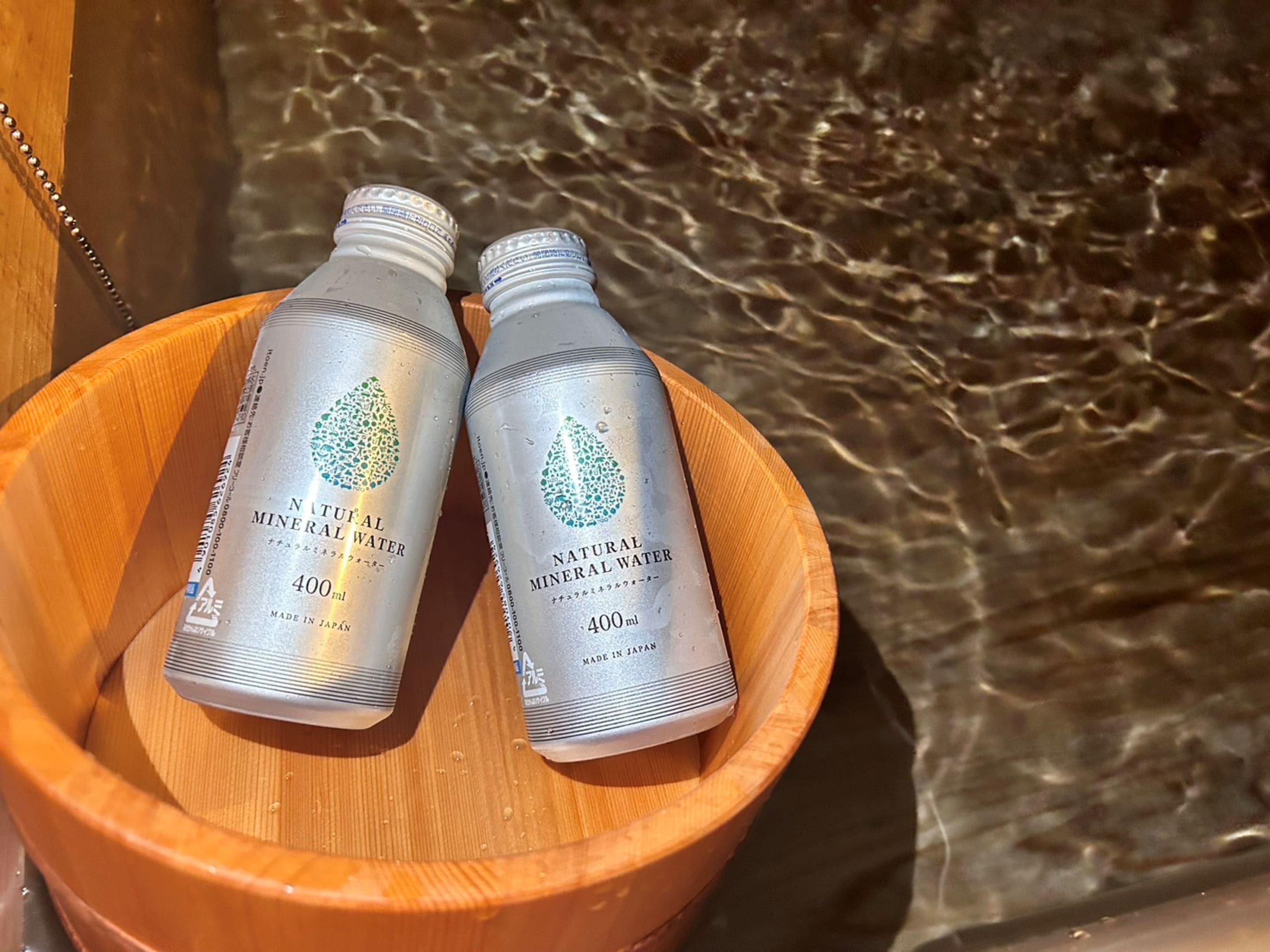 Two bottles of natural mineral water in a wooden bowl.