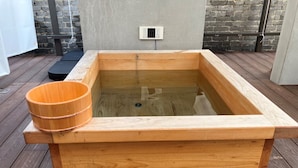 A wooden hot tub with a wooden bucket on top, placed on a wooden deck. - StayHakata villa  (Fukuoka)