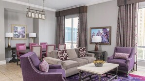 Una sala de estar con un conjunto de sofás, sillones, una mesa de centro y un comedor con sillas y una mesa.
