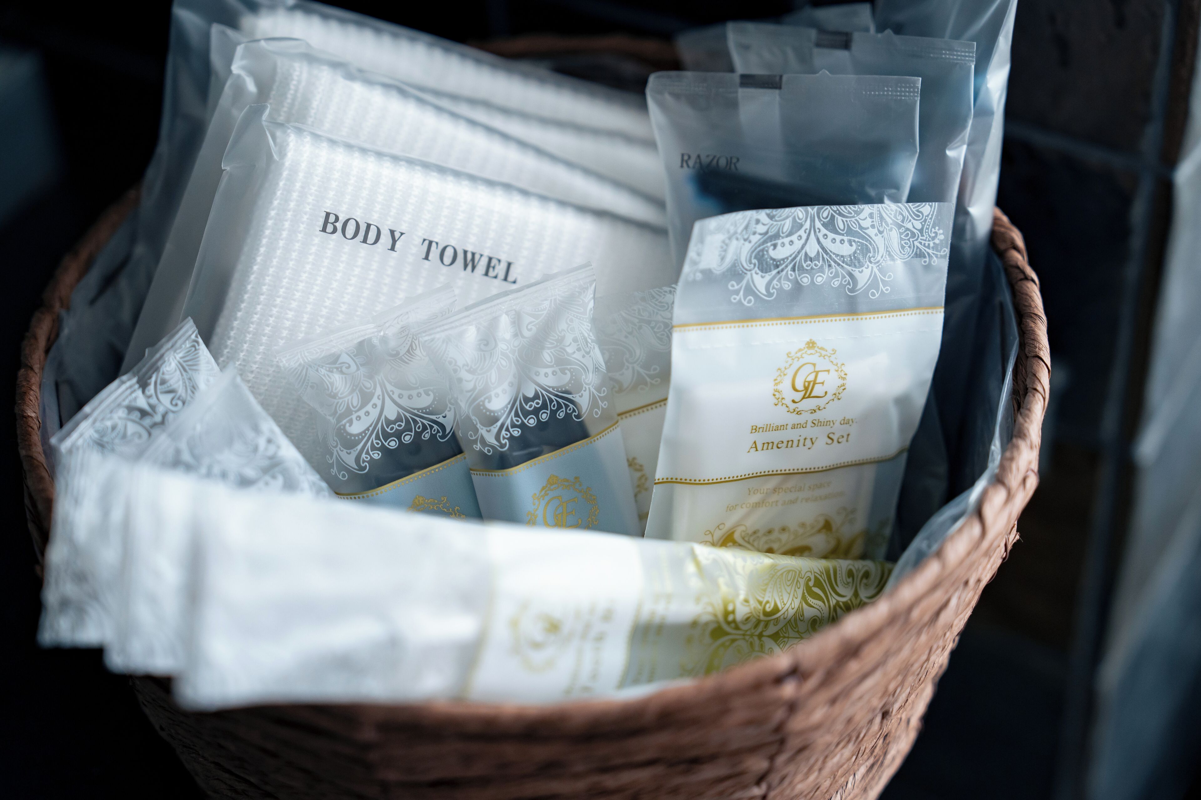A basket filled with various types of body towels, including a 'Body Towel' and a 'Brilliant and Shiny Day Amenity Set'.