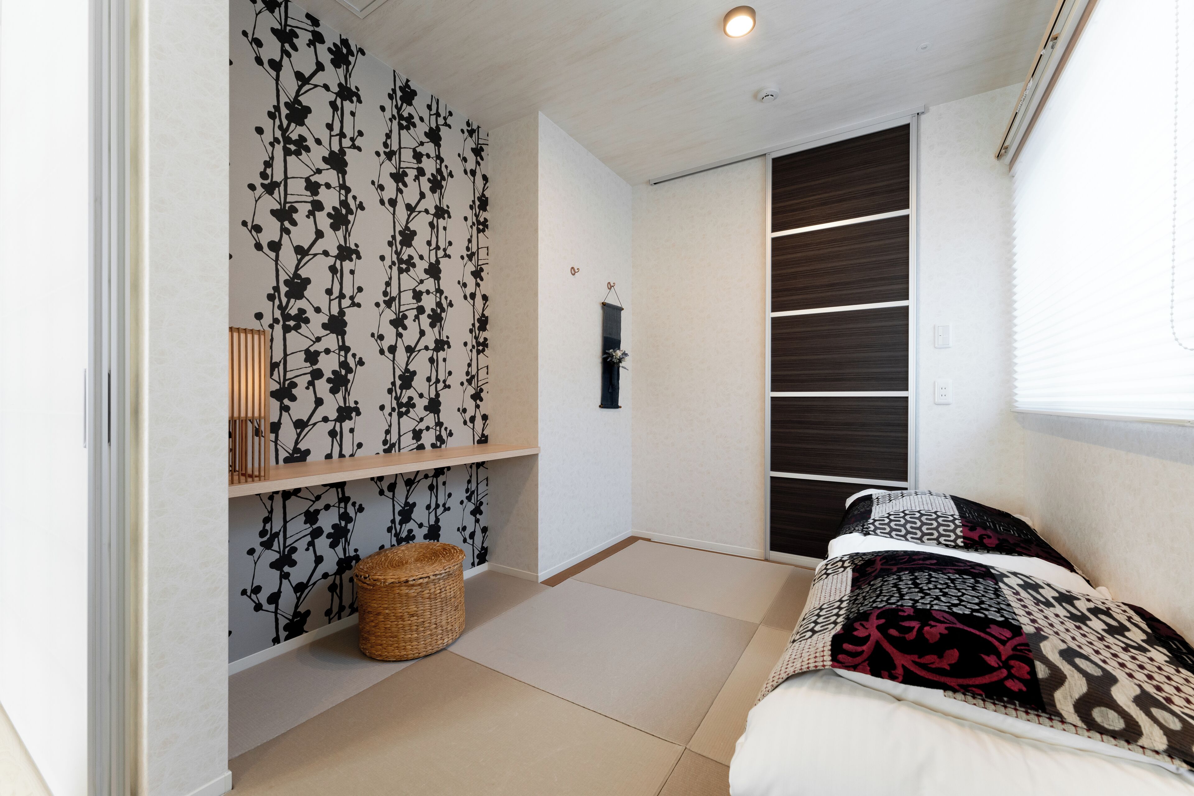 A bedroom with a bed, a wardrobe, a shelf with decorative items, and a woven basket on the floor.