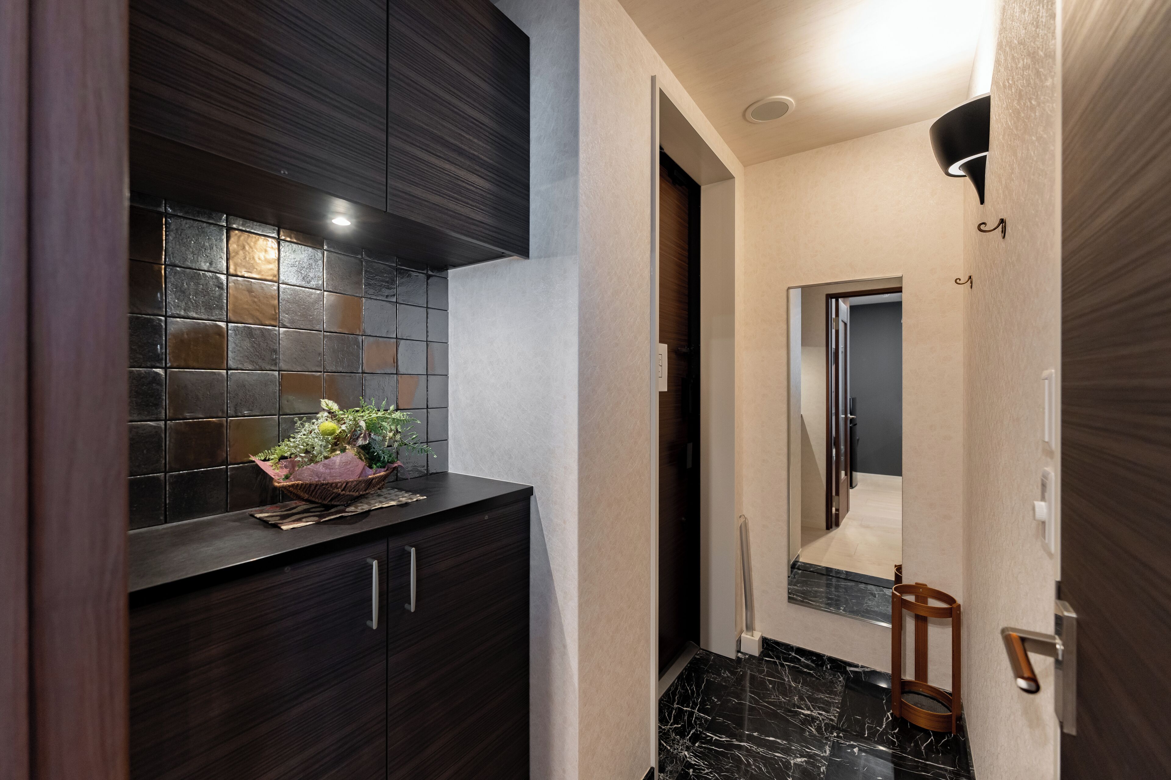 A modern bathroom with dark wooden cabinets, a tiled backsplash, and a marble floor.