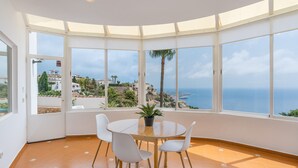 A room with a round table, white chairs, and a potted plant. - Villa 'Casa Naranjita' with Sea View, Wi-Fi and Heated Pool (Salobreña)