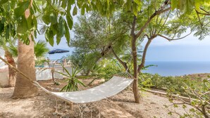 A hammock tied between trees, a brick pathway, and a view of the sea. - Villa 'Casa Naranjita' with Sea View, Wi-Fi and Heated Pool (Salobreña)
