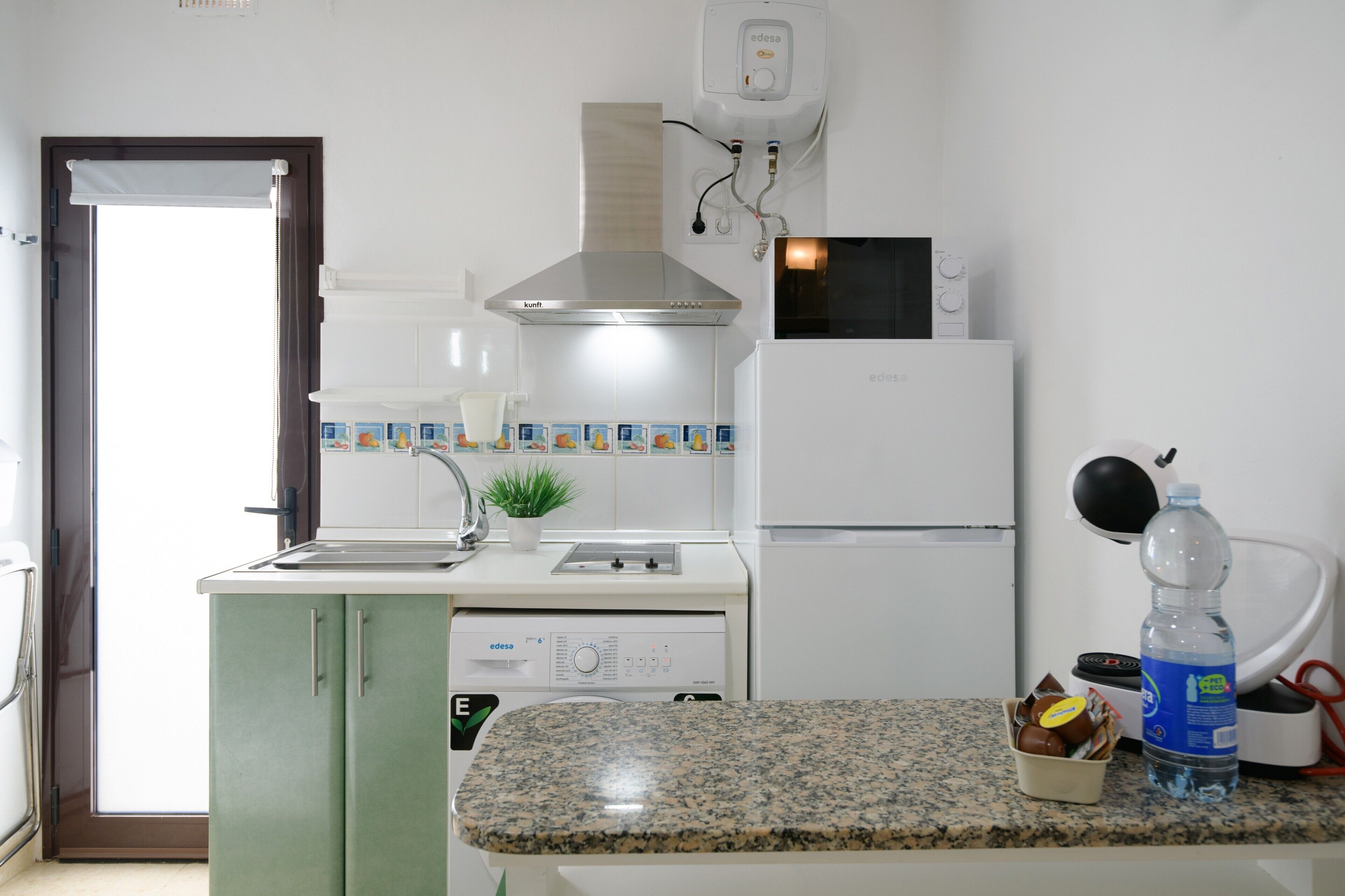 Une cuisine équipée d’un four à micro-ondes, d’une cuisinière et d’un réfrigérateur.