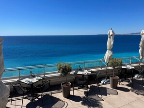 A terrace with outdoor seating, a view of the sea, and a railing. - Apartment with Partial Sea View, Parking, Wi-Fi, and Air Conditioning (Cannes)