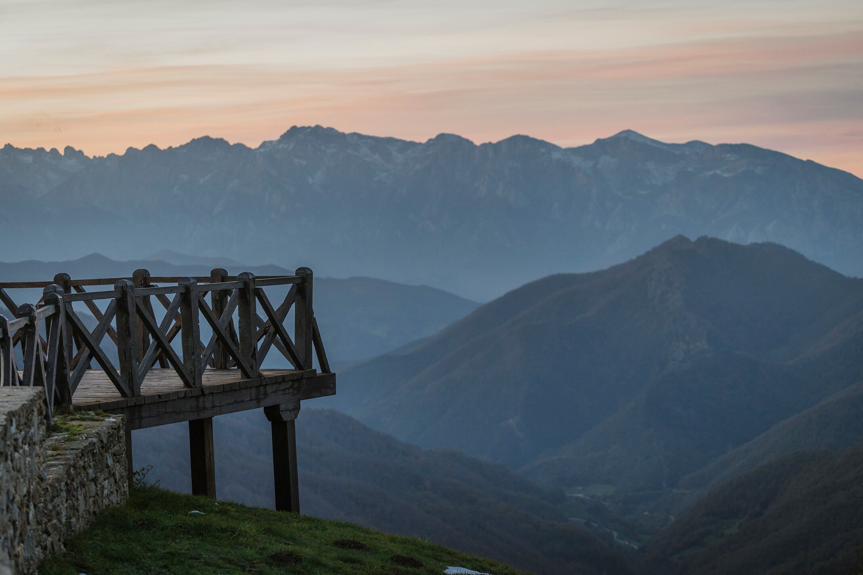 A wooden observation deck overlooking a mountainous landscape.