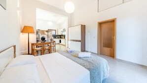 A hotel room with a bed, a desk, a chair, a wardrobe, and a door. - Melissa apartment - stunning sea views, large garden and parking (Korfu)