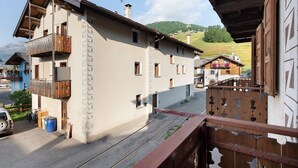A multi-story building with balconies, a garage, and a clear view of the surrounding landscape.