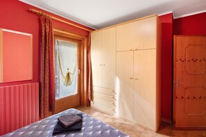Una camera da letto con un letto, un armadio e una finestra con tende.