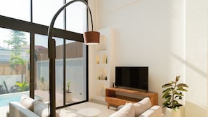 Una sala de estar moderna con un sofá, un televisor, una mesa de centro y una planta en maceta.