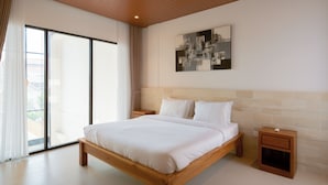 Un dormitorio moderno con una cama grande, cabecera de madera, una mesita de noche y una puerta corrediza de vidrio que da a un balcón.