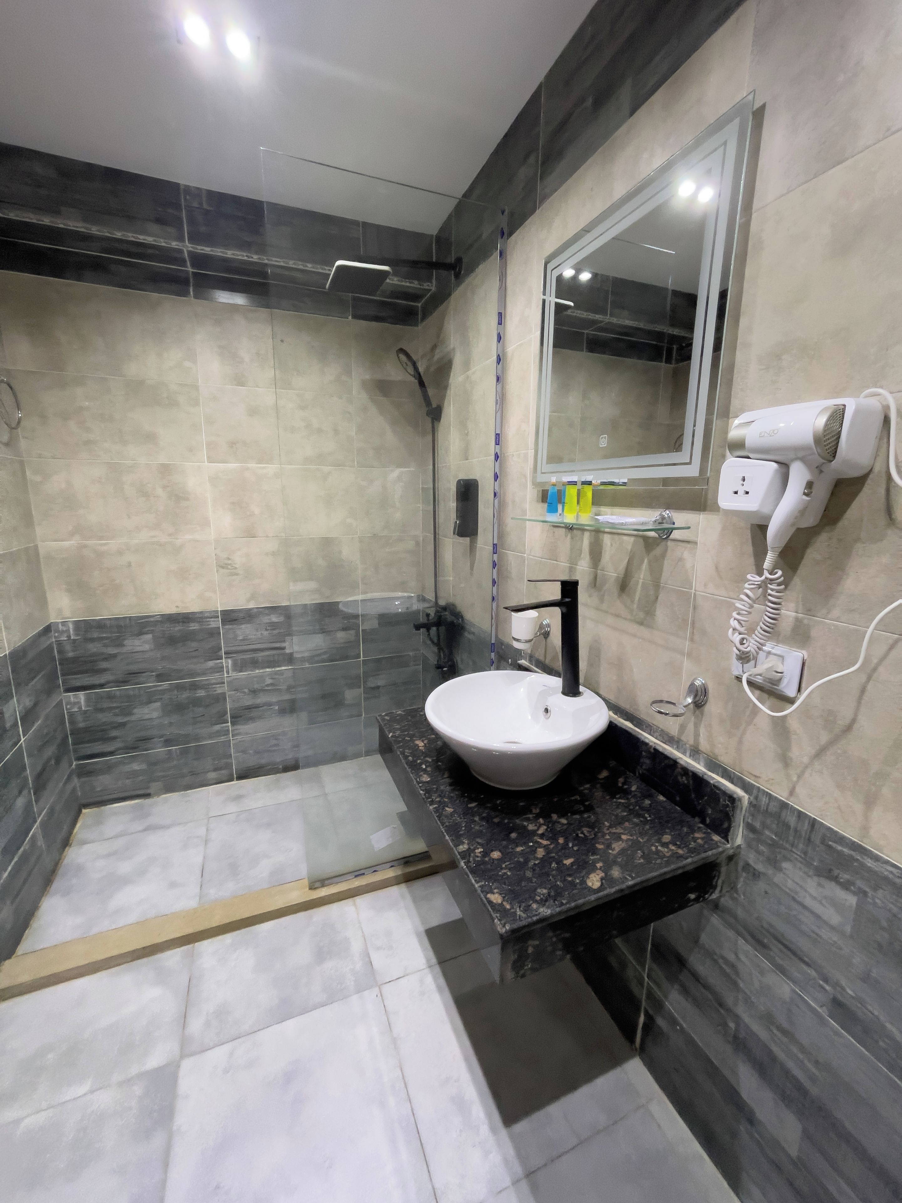 A modern bathroom with a sink, mirror, and hairdryer.