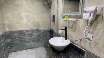 A modern bathroom with a sink, mirror, and hairdryer.