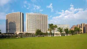 Un hôtel moderne à la façade incurvée, doté de plusieurs étages et d’un toit plat.