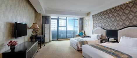 Habitación de hotel con una cama grande, televisión, escritorio con lámpara y vista a la ciudad.