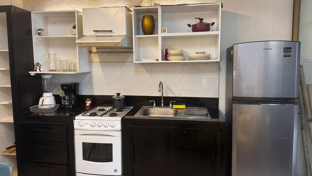 A compact kitchen with a stove, sink, and refrigerator. - Económico y Céntrico Departamento a Solo 15mtrs de la Playa (Puerto Vallarta)