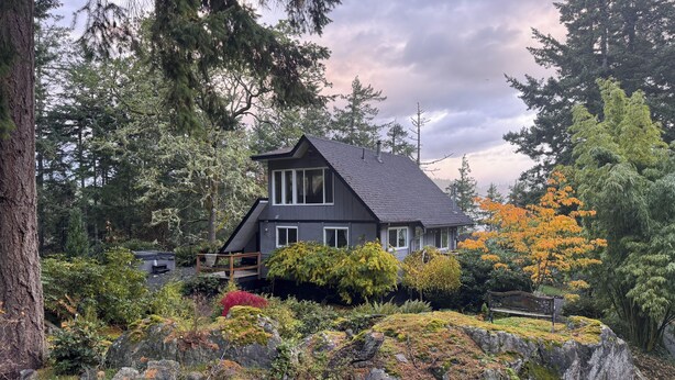 A two-story house surrounded by dense forest and autumn foliage. - Private Cabin w/ Hot Tub • Near Beaches & Trails 30 min from Victoria • King Bed (Victoria)