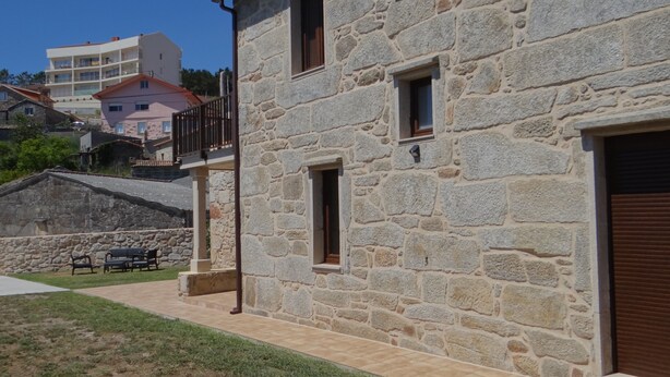 A stone building with a balcony, a small window, and a door.