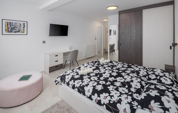 Una camera da letto moderna con un letto grande, una scrivania e una televisione.