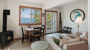Una sala de estar acogedora con chimenea, un comedor con vistas al exterior y un ventanal grande.